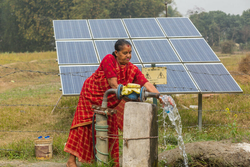Nepalese farmer with her solar irrigation pump. ©Photo credit: Nabin Baral/IWMI (CC BY-NC 2.0 DEED)