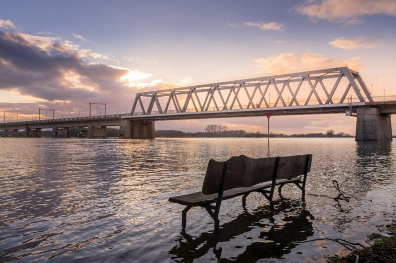 Bench in water with bridge in the background in Deventer, The Netherlands